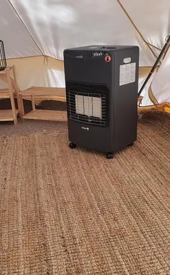 a heater is sitting in front of a tent at 