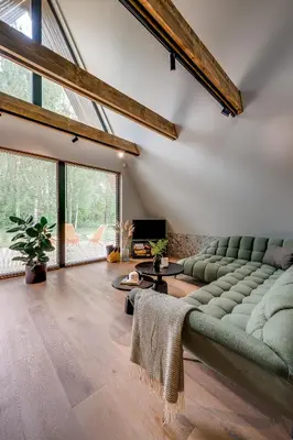 a living room with a couch and a table at Namas MIŠKE in Lazdinė