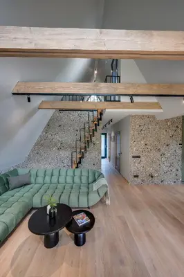 a living room with a green couch and a table at Namas MIŠKE in Lazdinė