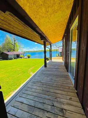 a porch of a house with a view of the water at AGUONA ROYAL OASIS in Molėtai