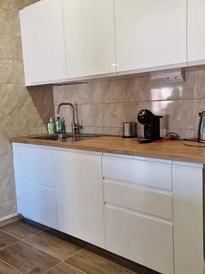 a kitchen with white cabinets and a sink at Alvydo apartamentai in Kaunas