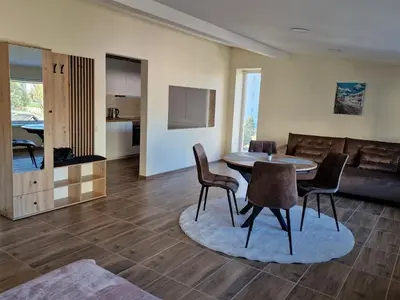 a living room with a table and chairs and a couch at Alvydo apartamentai in Kaunas