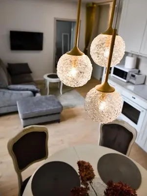 a living room with a table and four lights at Mickeviciaus 11-11 in Šiauliai