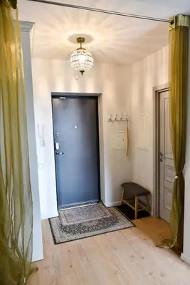 a hallway with a blue door and a chair at Mickeviciaus 11-11 in Šiauliai