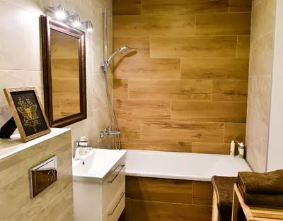 a bathroom with a tub and a sink and a mirror at Mickeviciaus 11-11 in Šiauliai