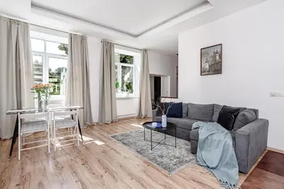 a living room with a couch and a table at Spacious City Centre Apartment with Parking SELF CHECK-IN in Vilnius