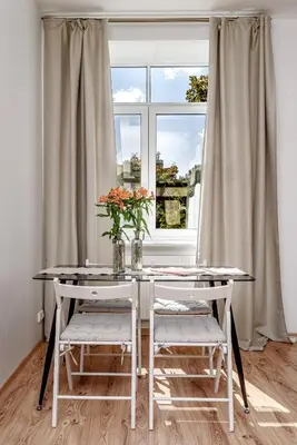 a white table with two chairs and a window at Spacious City Centre Apartment with Parking SELF CHECK-IN in Vilnius