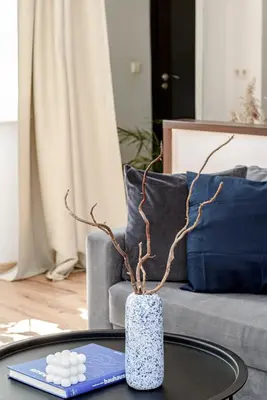 a vase sitting on a coffee table in front of a couch at Spacious City Centre Apartment with Parking SELF CHECK-IN in Vilnius