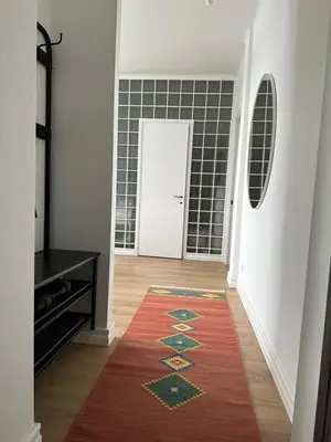 a hallway with a red rug and a white door at Šiauliai CENTER Višinskio NEW self check In in Šiauliai