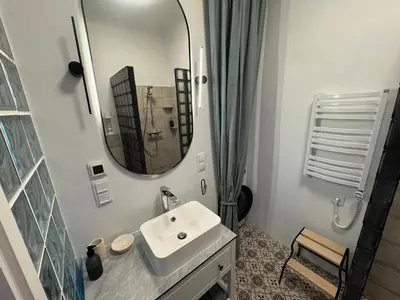 a white bathroom with a sink and a mirror at Šiauliai CENTER Višinskio NEW self check In in Šiauliai
