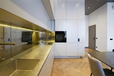 a kitchen with white cabinets and a dining table at Forentinn Gedimino pr. in Vilnius