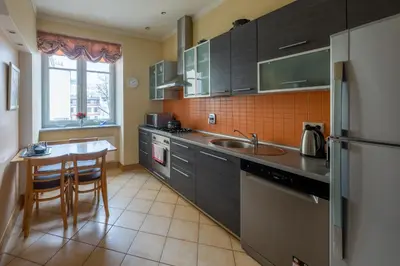 a kitchen with a sink and a table in it at HaPPy Inn ArkA the heart of Old Town, Self-Check-in, A-C, Car-Parking, Balkony in Vilnius