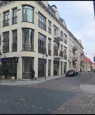 a man walking down a street in front of a building at HaPPy Inn ArkA the heart of Old Town, Self-Check-in, A-C, Car-Parking, Balkony in Vilnius