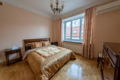 a bedroom with a bed and a window and a chandelier at HaPPy Inn ArkA the heart of Old Town, Self-Check-in, A-C, Car-Parking, Balkony in Vilnius