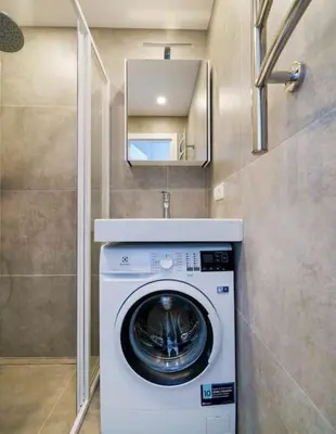 a washer and dryer in a small bathroom at Stylish Studio in Central Vilnius II in Vilnius