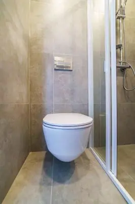 a bathroom with a white toilet and a shower at Stylish Studio in Central Vilnius II in Vilnius