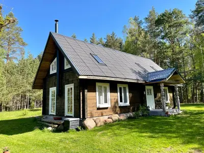 a small house with a roof on a grass field at Holiday homestead Camp of Forest Souls in Masališkės