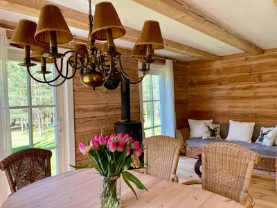 a dining room with a table with flowers on it at Holiday homestead Camp of Forest Souls in Masališkės