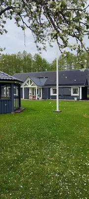 a house with a pole in the middle of a field at Perlytė in Metelyte
