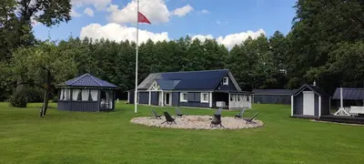 a house with a flag in front of a yard at Perlytė in Metelyte