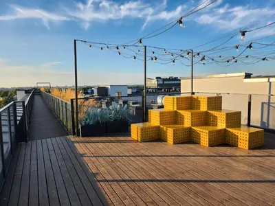 a deck with yellow seats on top of a building at Radio City loft - apartment 420 in Kaunas