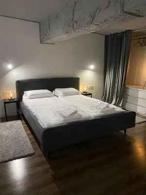 a bedroom with a large bed with white sheets at Radio City loft - apartment 420 in Kaunas