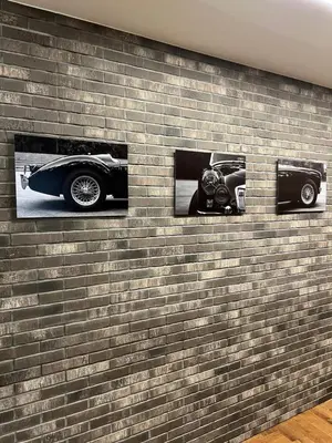 a brick wall with three pictures of a car on it at 101 Large Space in Kaunas