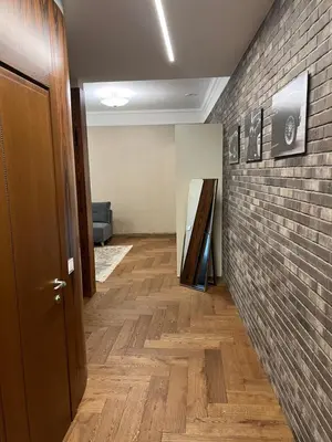 a hallway with a brick wall and a wooden floor at 101 Large Space in Kaunas
