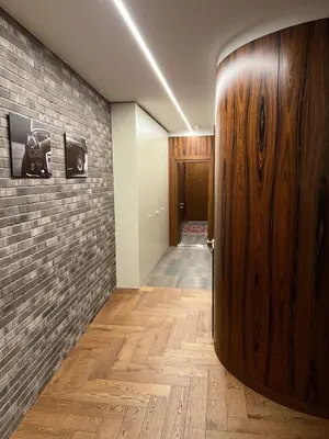 a hallway with a wooden door and a brick wall at 101 Large Space in Kaunas