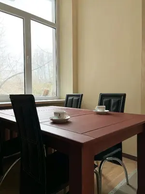 a dining room table with chairs and a large window at Apgyvendinimo įstaiga KORNEALITA in Zarasai