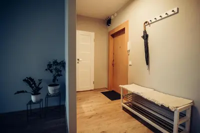 a hallway with an umbrella hanging on a wall at Pine Apartment in Visaginas