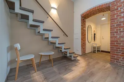 a staircase in a living room with a brick wall at Freedom Avenue Apartment by Polo apartments in Kaunas