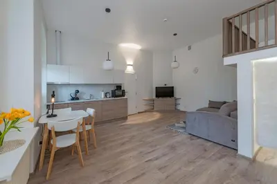 a kitchen and living room with a table and a couch at Freedom Avenue Apartment by Polo apartments in Kaunas