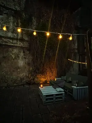 a patio with a couch and lights at night at Capital's Old Town Gem in Vilnius