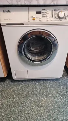 a white washing machine sitting on top of a counter at Capital's Old Town Gem in Vilnius
