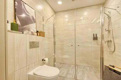 a bathroom with a toilet and a glass shower at Home in in Druskininkai