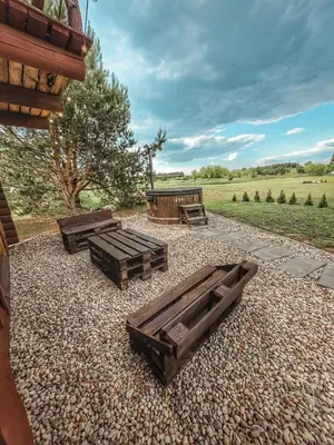 a group of picnic tables on a gravel patio at Poilsis netoli Druskininkų in Druskininkai