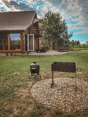 a bbq and a grill in front of a house at Poilsis netoli Druskininkų in Druskininkai