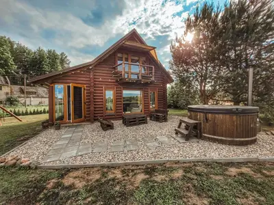 a log cabin with a hot tub in the yard at Poilsis netoli Druskininkų in Druskininkai