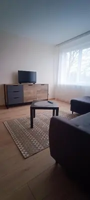 a living room with a tv and a coffee table at Adomo Apartamentai Panevėžyje in Panevėžys