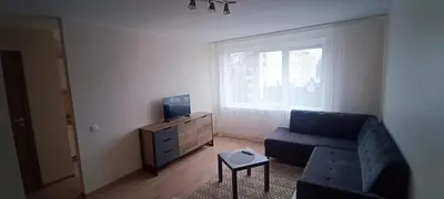 a living room with a blue couch and a tv at Adomo Apartamentai Panevėžyje in Panevėžys