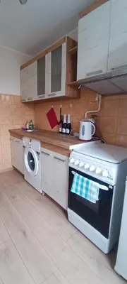 a kitchen with a stove and a washing machine at Adomo Apartamentai Panevėžyje in Panevėžys
