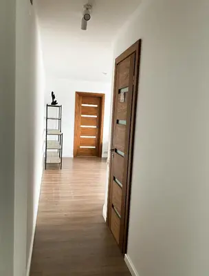 a hallway with a door and a wooden floor at 