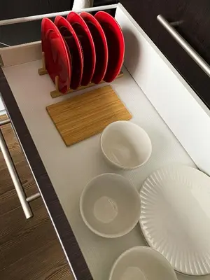 a counter with white plates and a red container at 