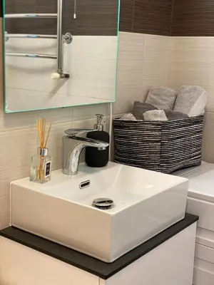 a white sink in a bathroom with a basket of towels at 