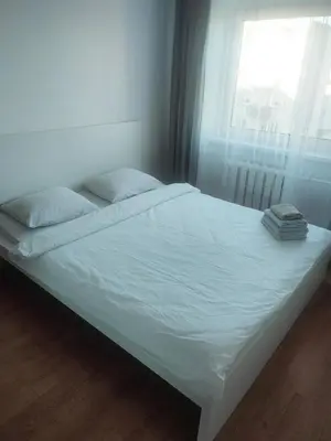 a bed with white sheets and a window in a room at 