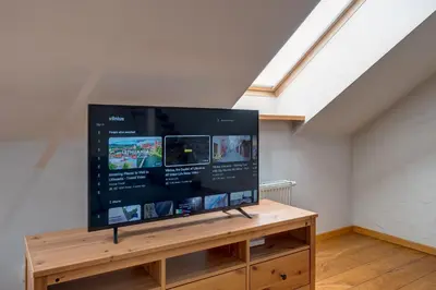 a large flat screen tv on a wooden stand in a room at Charming Loft in Vilnius Oldtown in Vilnius