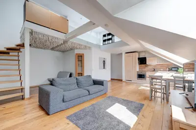 a living room with a couch and a kitchen at Charming Loft in Vilnius Oldtown in Vilnius