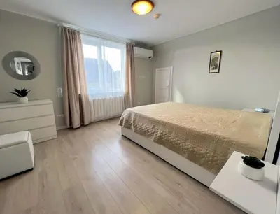 a bedroom with a bed and a large window at Kotedžas nuomai - Retro 70, Šiauliai in Šiauliai