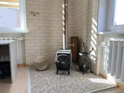 a wood stove in a room with a fireplace at Kotedžas nuomai - Retro 70, Šiauliai in Šiauliai
